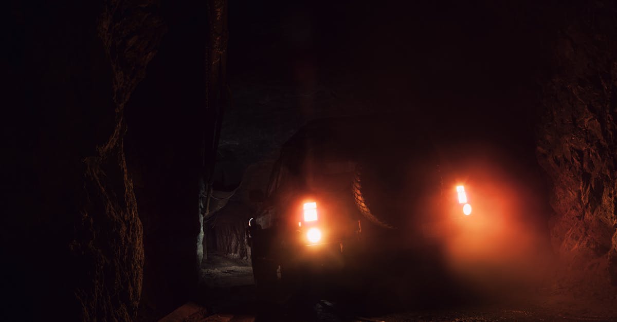 An off-road vehicle with headlights on in a dark underground tunnel in BC, Canada.