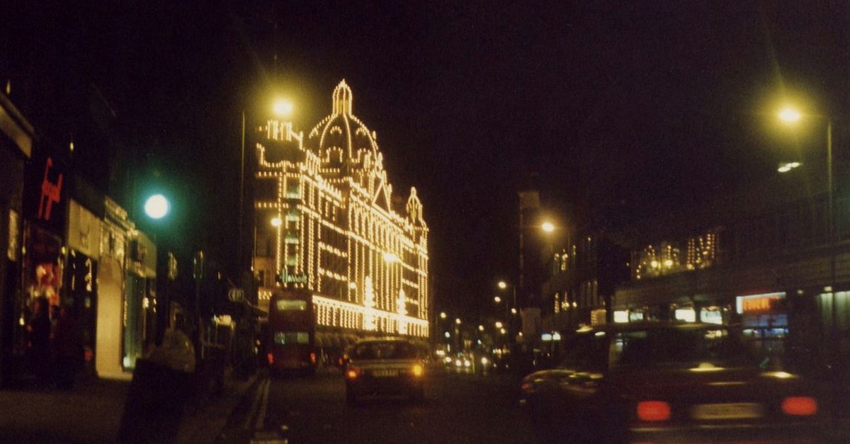 Captivating nighttime street scene showcasing an illuminated city building with bustling traffic.