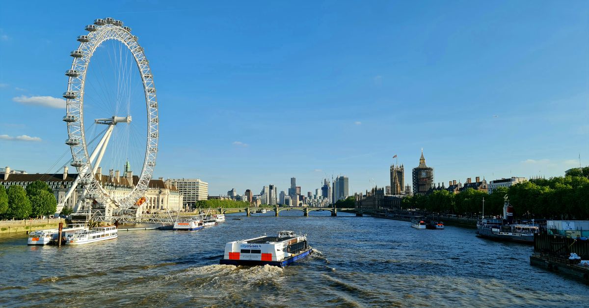 A vibrant view of the London Eye and Thames River on a sunny day showcasing London's landmarks.