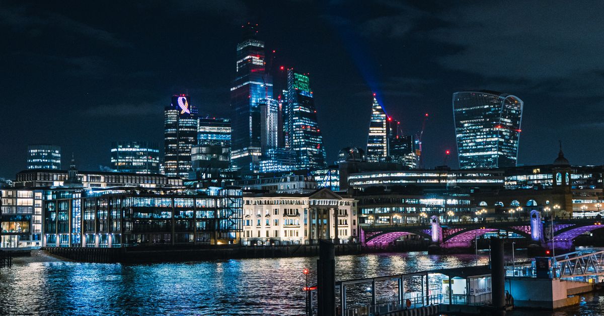 A vibrant view of London's illuminated skyline and River Thames at night.