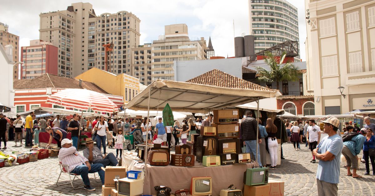 Explore a bustling street market in Curitiba with vintage items and urban energy.