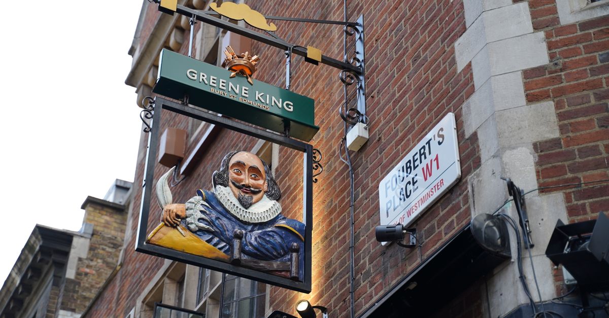 Close-up of a Shakespeare-themed pub sign on a historic London street, vibrant urban setting.