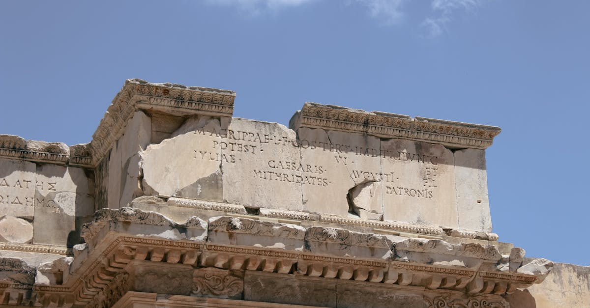Detailed view of ancient Roman ruins showcasing inscriptions and architectural details under a clear sky.