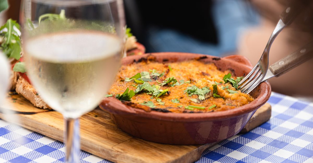 A delicious Portuguese dish served with white wine in a restaurant setting in Faro, Portugal.
