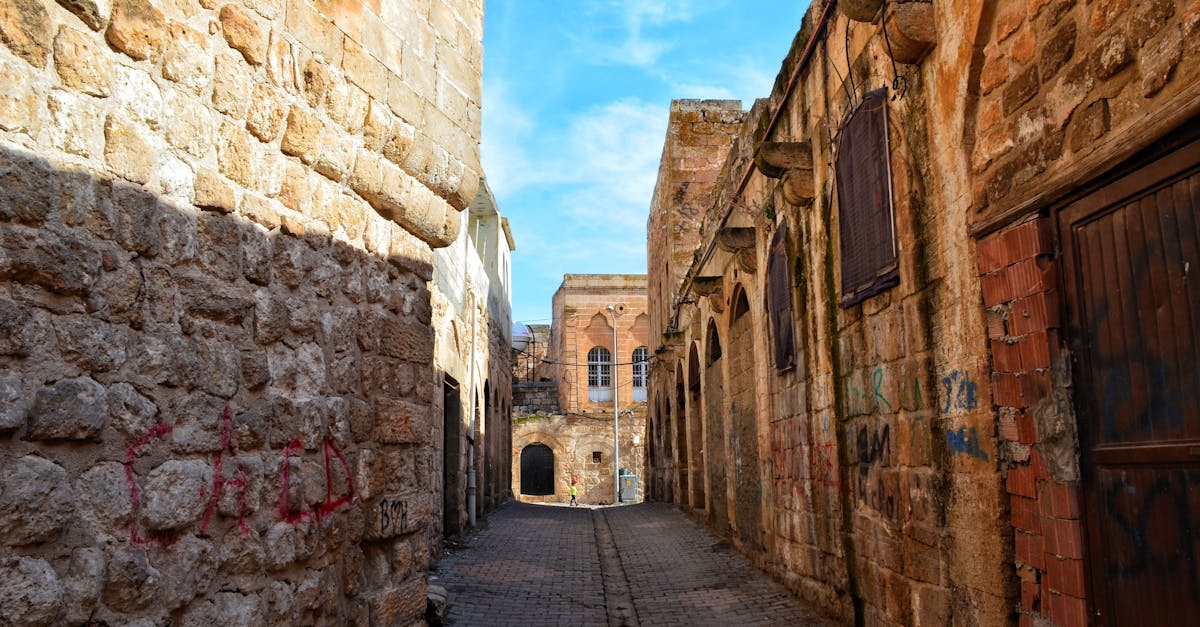 Explore the charm of an ancient narrow alley with rustic stone architecture and graffiti.