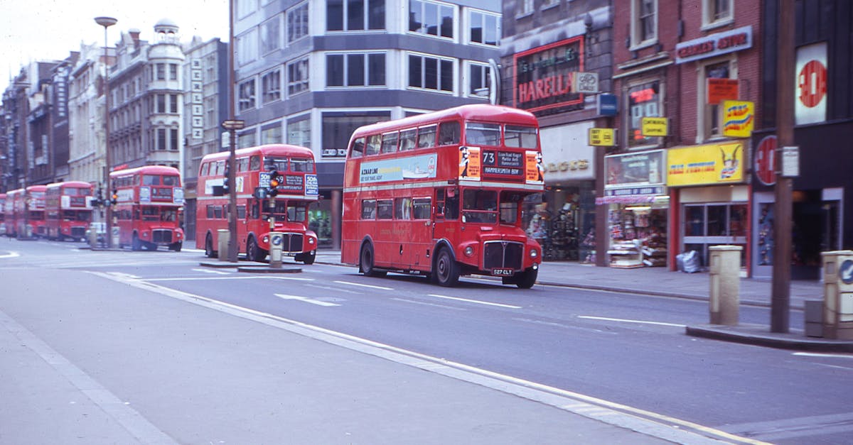 A row of iconic red double-decker buses on a busy city street.