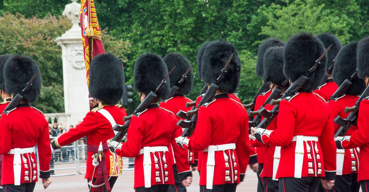 British Queen's Guards march with rifles during a Buckingham Palace ceremony.