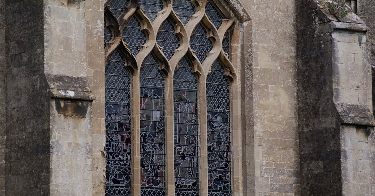 Close-up of a historic Gothic stained glass window in England, showcasing intricate design.