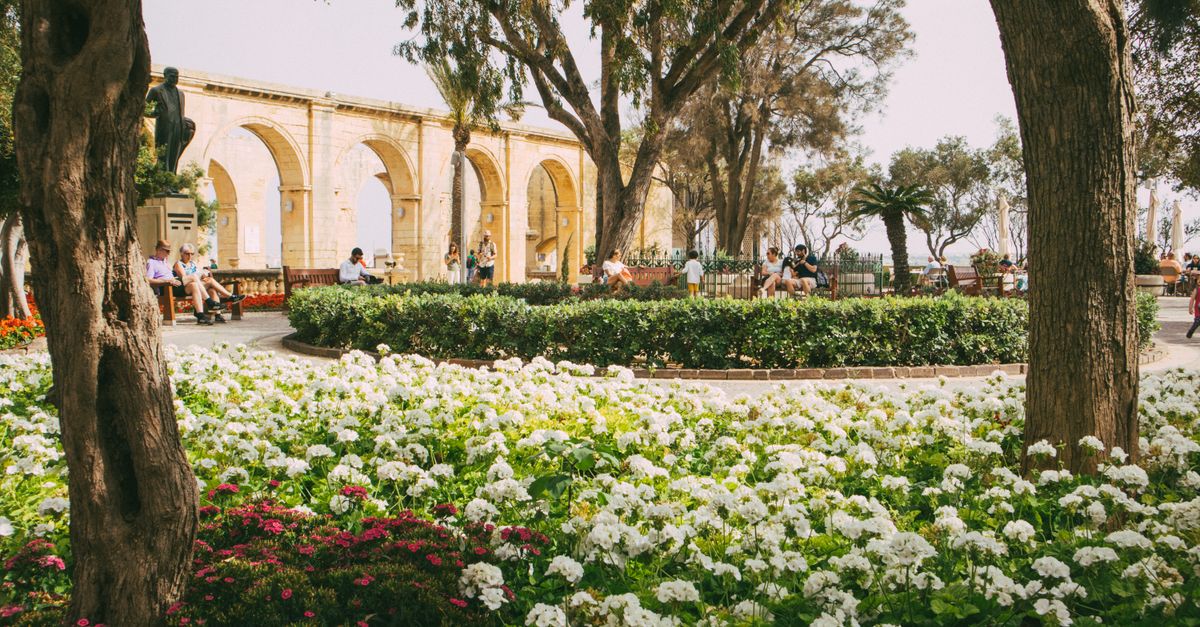 Lush garden with flowers and people enjoying Upper Barrakka Gardens' scenic view, perfect for travel inspiration.