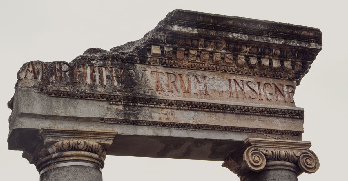 Close-up of ancient Roman ruins in Sicilì, Italy showcasing detailed stone columns and inscriptions.