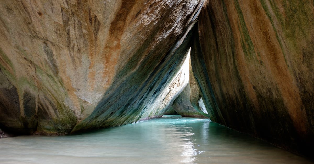 Explore the serene beauty of a secluded tropical cave with tranquil water and unique rock formations.