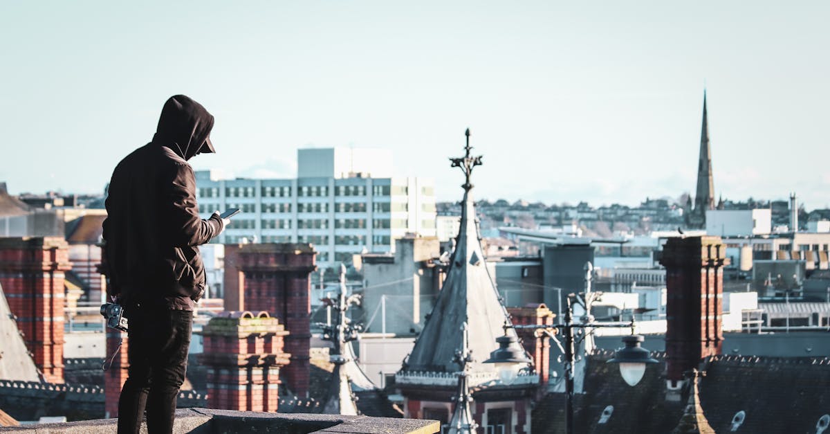 Man in hoodie exploring Bristol's skyline during the day.