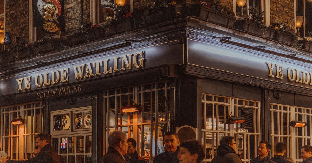 Nighttime scene at Ye Olde Watling Pub in London, capturing city life and local culture.