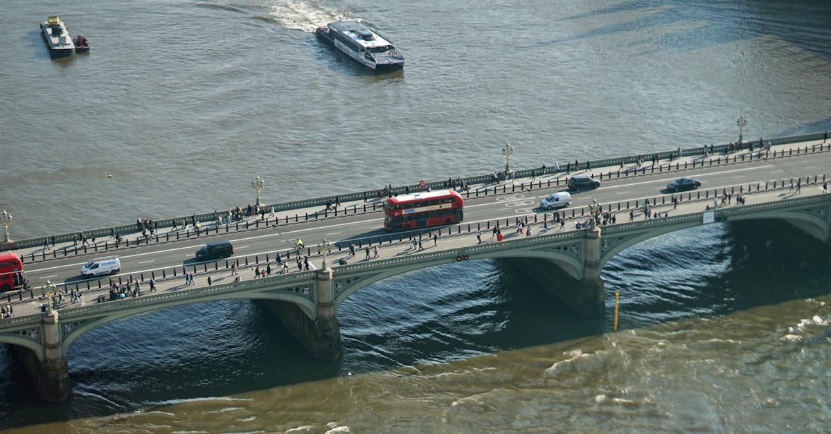 Aerial shot showcasing traffic and pedestrians on a London bridge over the River Thames.