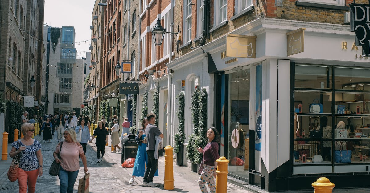 Busy urban street in London with diverse people walking along cobblestone paths and shopping.