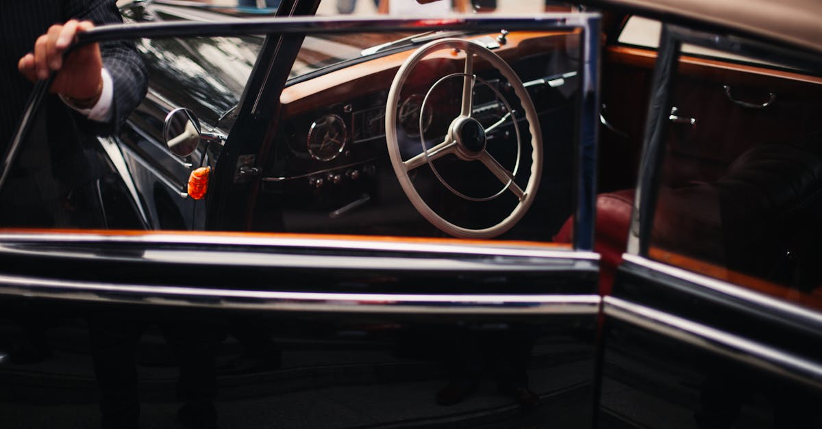 Close-up of an elegant vintage car interior, highlighting its classic steering wheel and luxurious details.