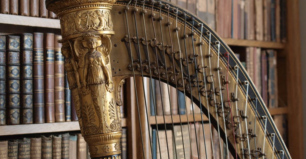 Close-up of a golden harp in a vintage library with classic bookshelves.