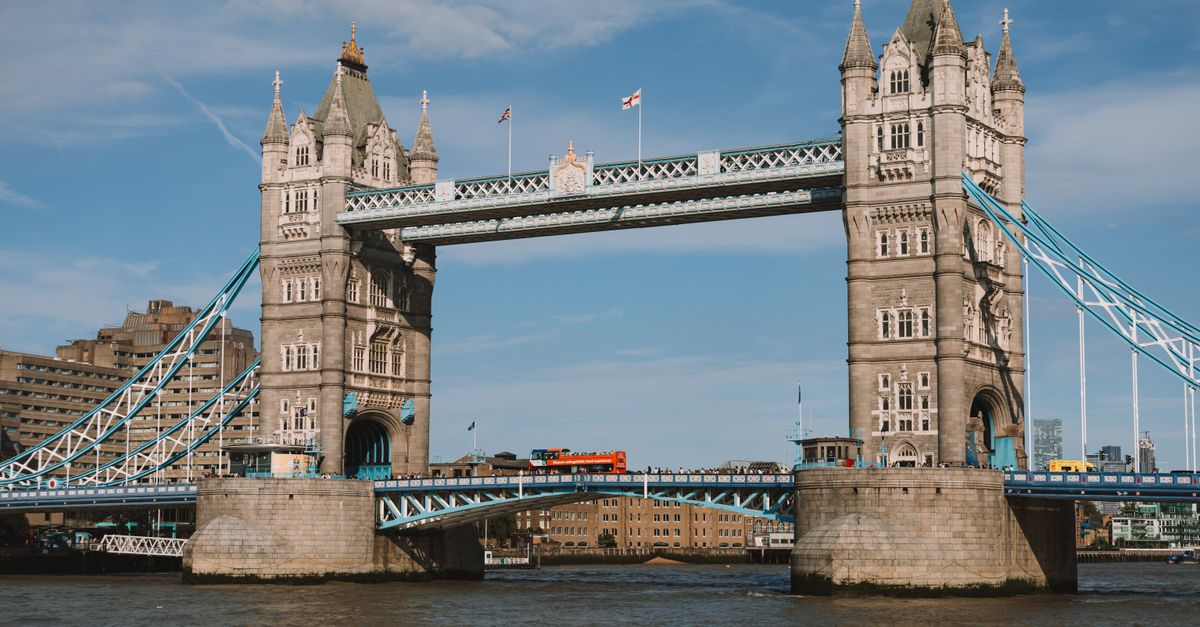 Stunning daytime shot of the iconic Tower Bridge in London, showcasing blue skies and an urban riverscape.