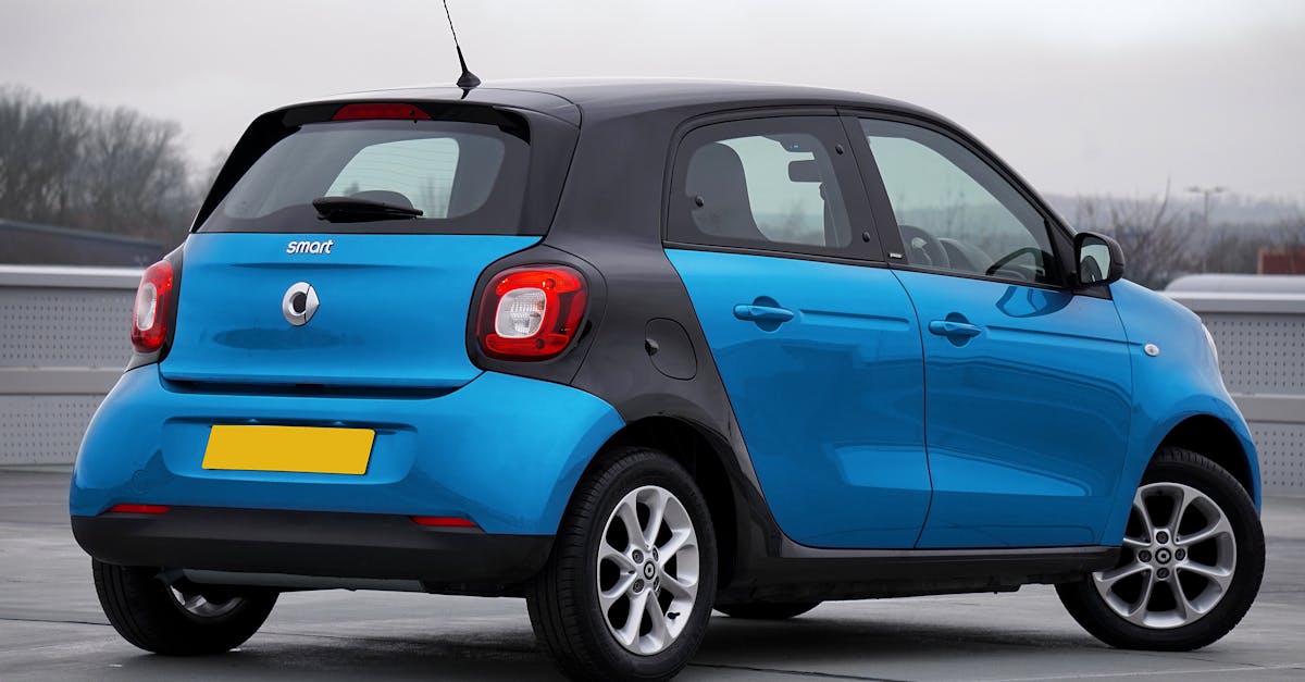 A blue Smart car parked outdoors viewed from the back, highlighting urban mobility.