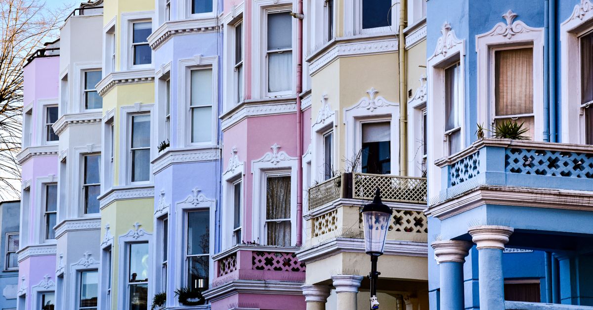 Charming pastel-colored homes line a quiet street in Notting Hill, London.