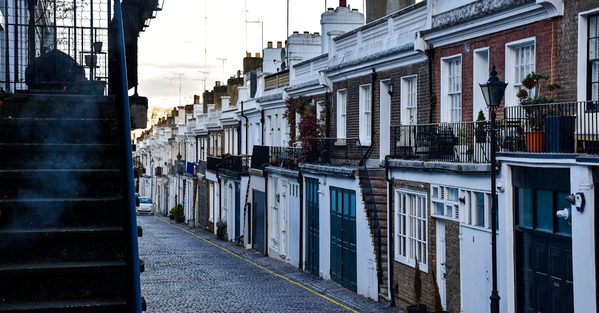 Cobbled street lined with classic townhouses in a quiet London residential district.