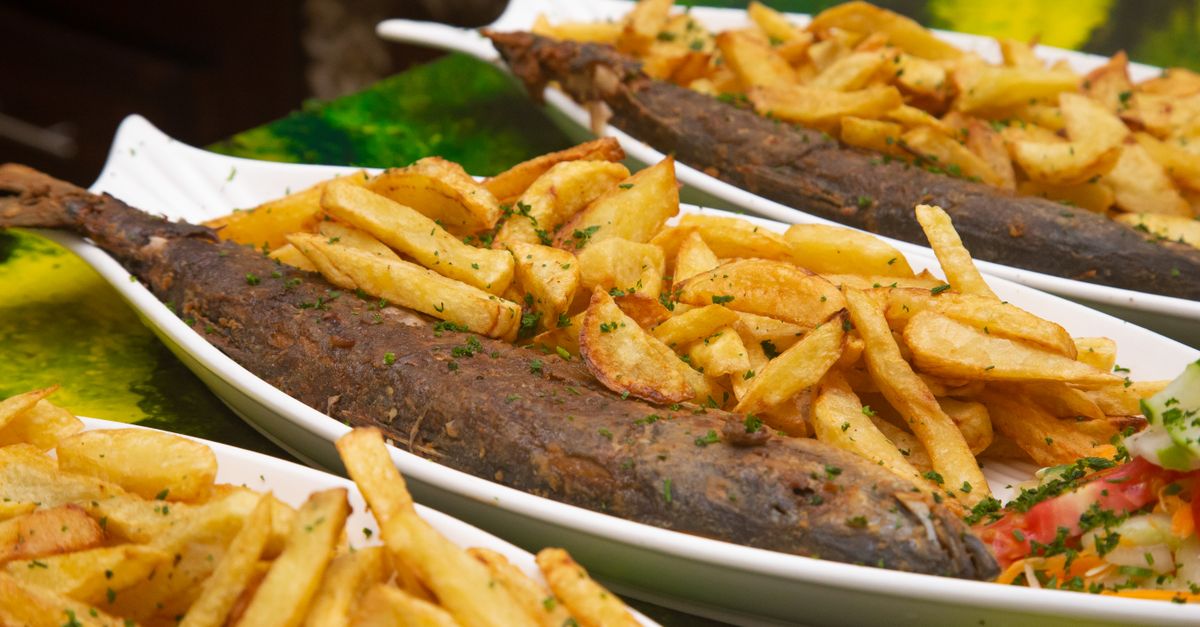 Delicious meal of crispy fried fish with golden French fries served on white plates, perfect for food photography.