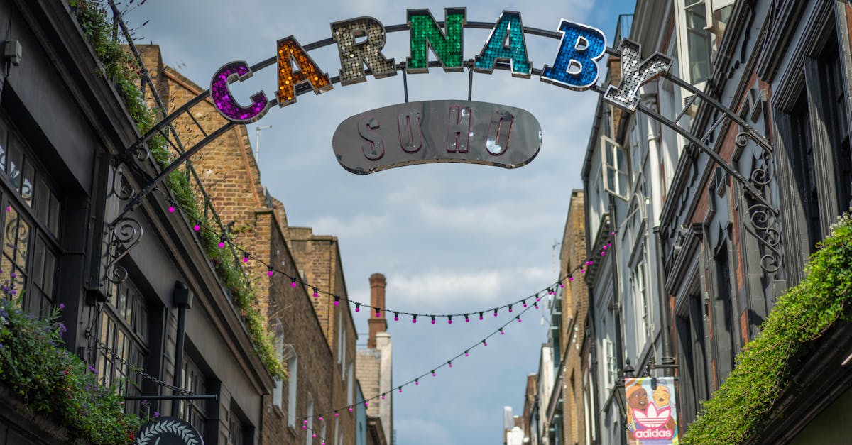 Vibrant Carnaby Street sign in Soho, London, under a blue sky.
