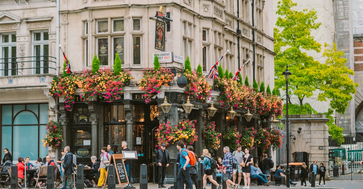Historic London pub with colorful flowers and bustling street corner ambiance.