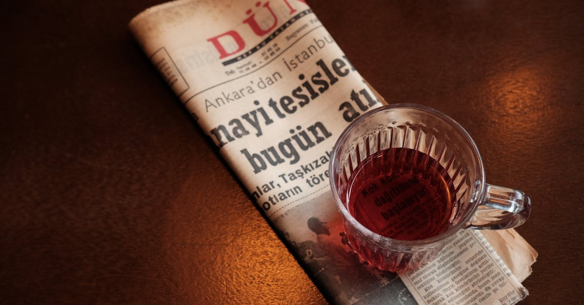 A cozy setting with a cup of tea and Turkish newspaper on a wooden table.