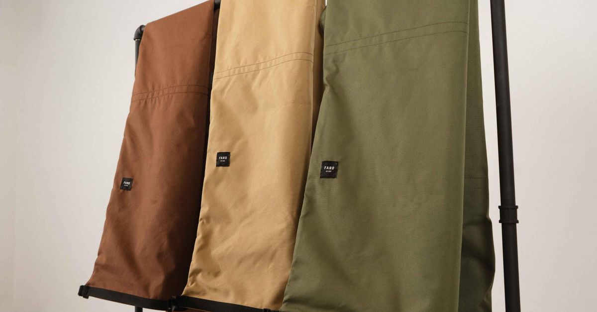 Stylish brown, beige, and green trousers neatly displayed on a black clothing rack indoors.