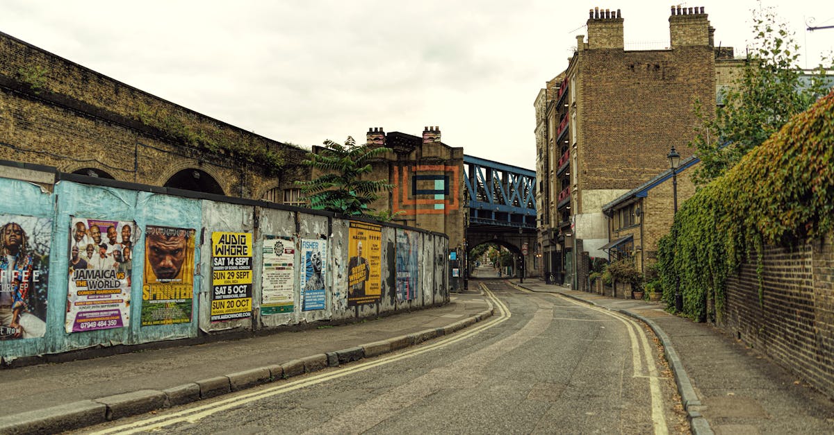 Empty street in London with colorful posters and historic architecture.