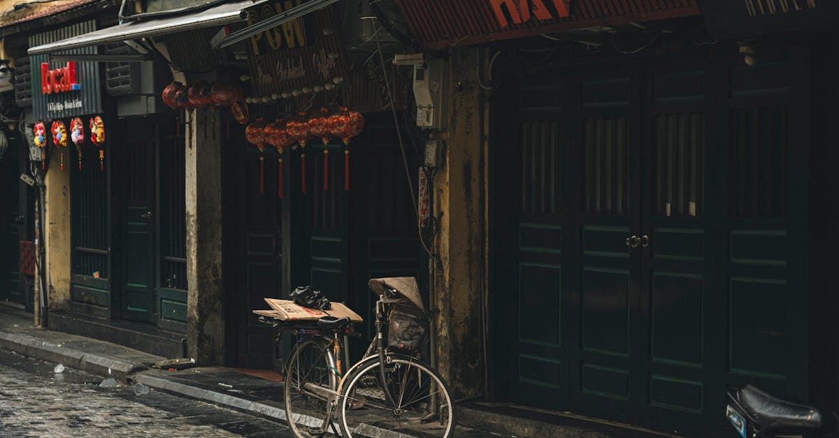 An old bicycle parked on a rainy day in a quiet, atmospheric city street.