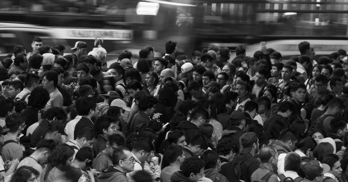 A dense, monochrome crowd navigating city streets, reflecting urban life.