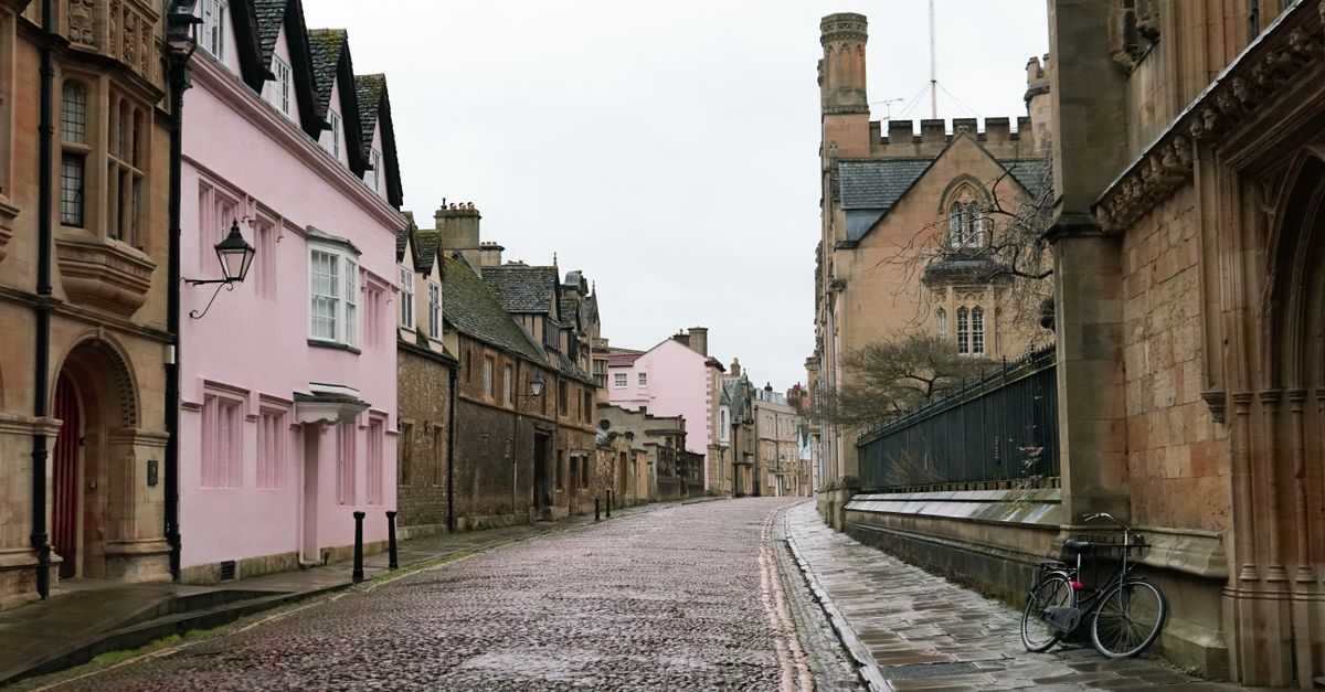 Charming cobblestone street with Gothic architecture in historic Oxford, England.