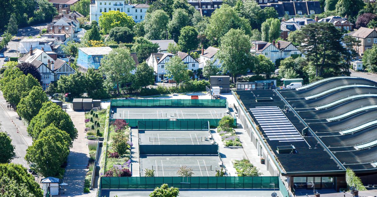 A bird's-eye view of tennis courts amidst a lush suburban neighborhood, showcasing urban greenery.