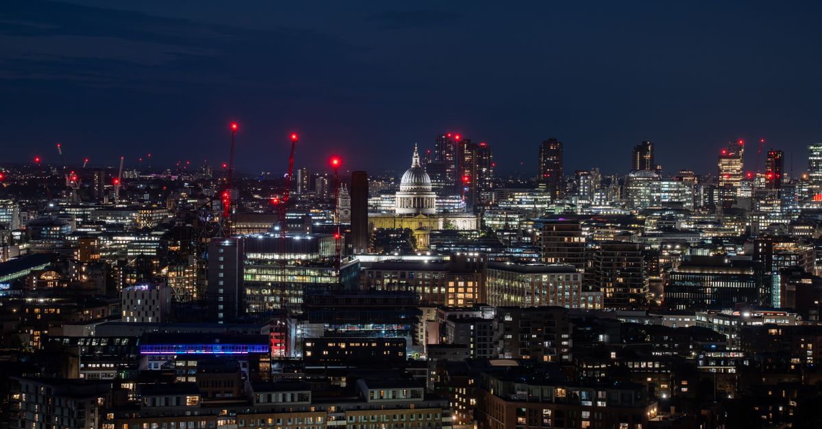 Beautiful nighttime view of London's skyline with St. Paul's Cathedral illuminated among city lights.