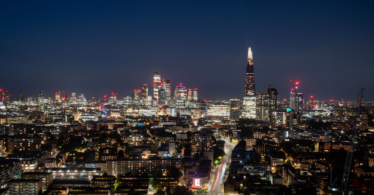 Capture a mesmerizing view of London's skyline featuring The Shard and skyscrapers illuminated at night.