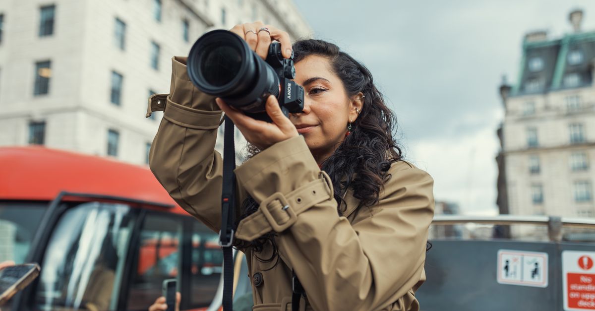 A woman takes photos on a city sightseeing tour, embodying urban exploration.