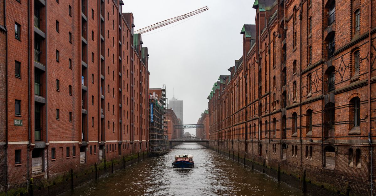 Charming view of boat sailing through historic Speicherstadt canal in Hamburg.