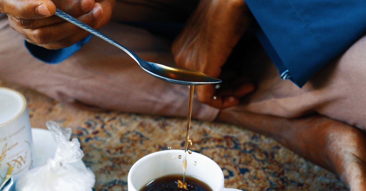 Close-up of a traditional tea pouring ritual in Abuja, Nigeria, showcasing cultural practices.