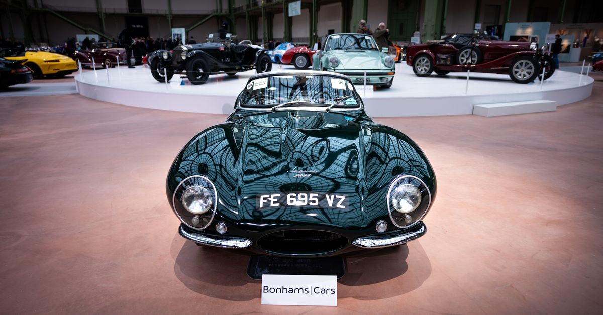 A classic car displayed at an auto exhibition with other vintage vehicles.