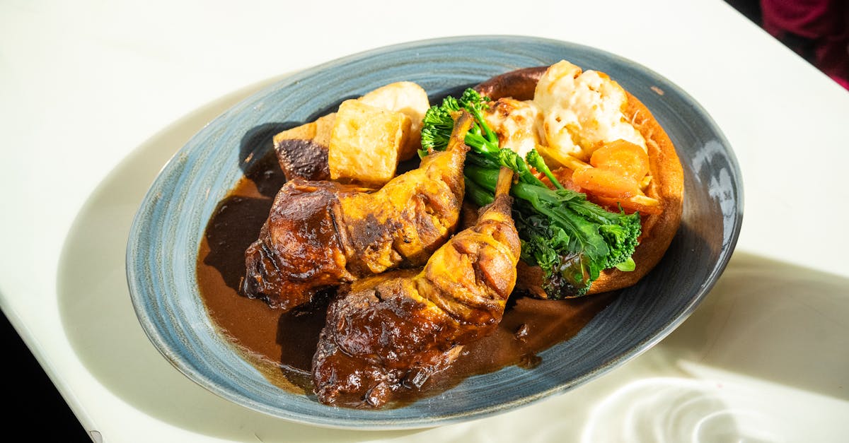 A scrumptious roast dinner featuring meat, vegetables, and gravy on a white table.