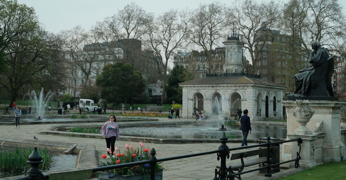 Serene spring day at Italian Gardens, Hyde Park, London with people, fountains, and tulips.