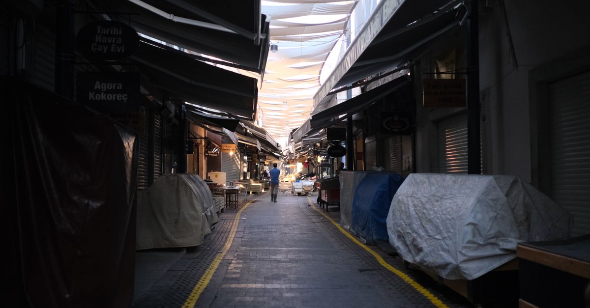 A quiet market alleyway with colorful canopies overhead, capturing an urban setting