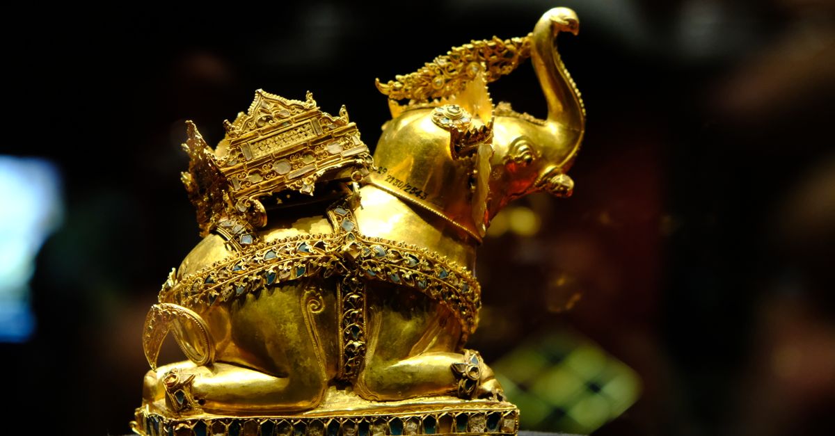 Intricate golden elephant sculpture on display in Ayutthaya's museum, symbolic of Thai art and culture.