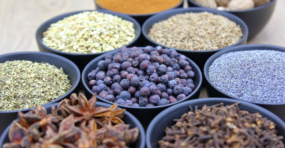 Top view of assorted spices in black bowls showcasing different colors and textures.