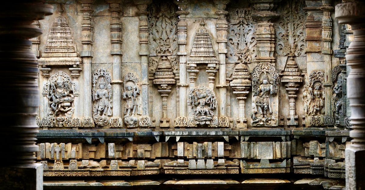 Detailed view of ancient stone carvings at a temple in Karnataka, India.