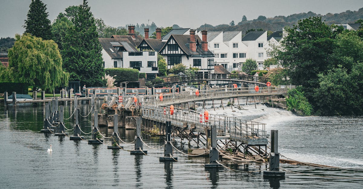 Picturesque view of traditional houses and a weir on the Thames River in London, UK.