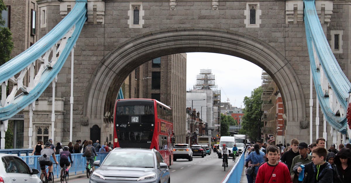 Crowds and traffic cross Tower Bridge in London, showcasing a busy urban scene.