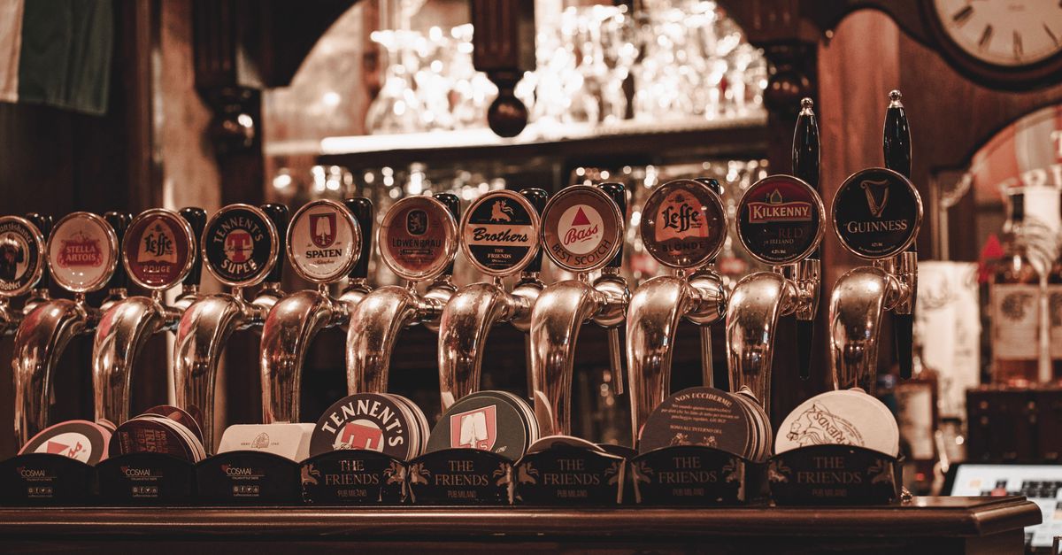 A row of vintage beer taps serving classic brews in a Milan pub.